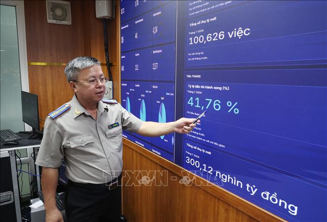 Ông Đỗ Phong Hóa, Phó Trưởng Thi hành án dân sự TP. Hồ Chí Minh, theo dõi dữ liệu trên Trung tâm Giám sát và Điều hành thông minh (IOC THADS). (Ảnh: Hồng Đạt/TTXVN)